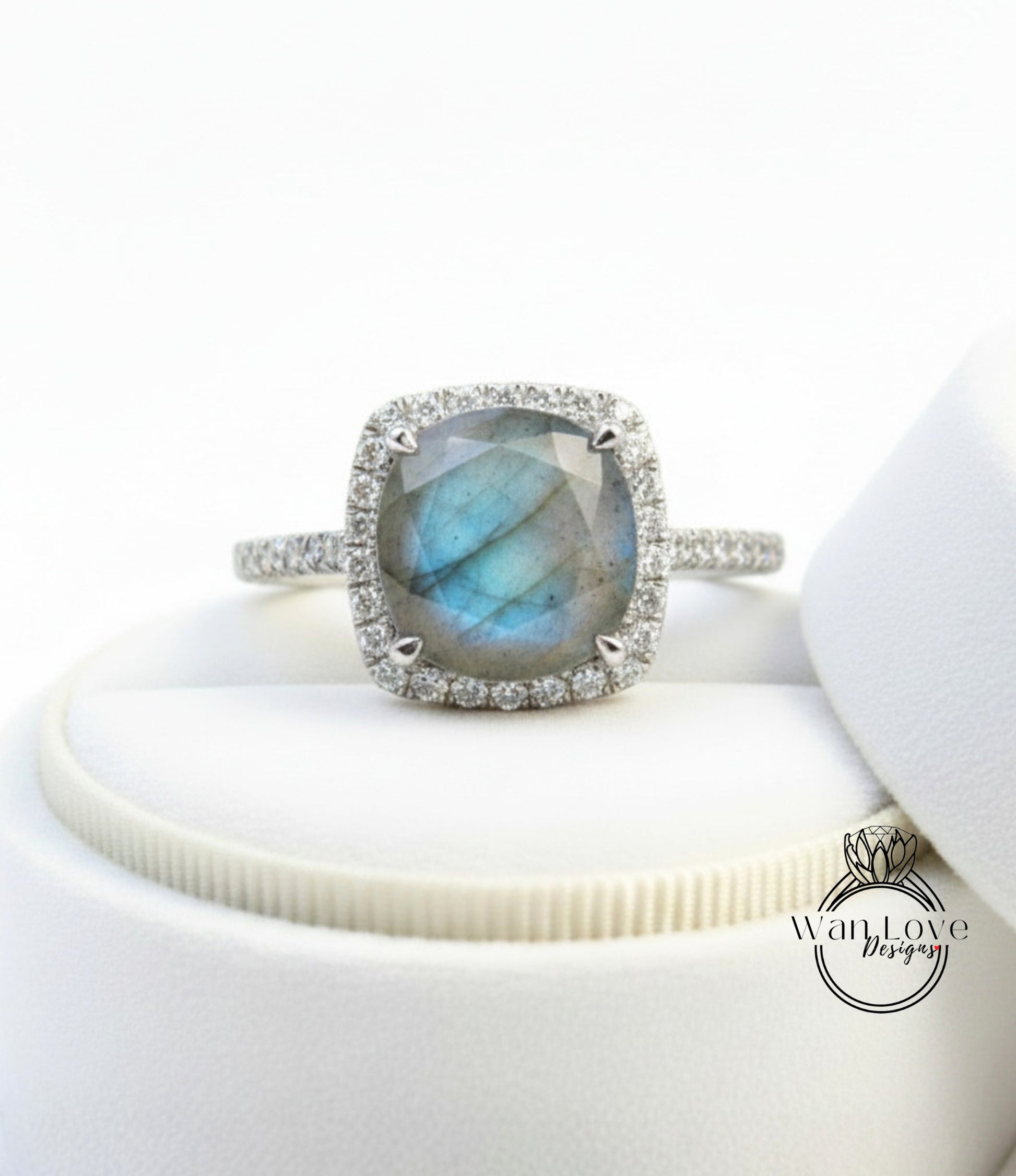 A silver ring with a large blue gemstone, likely a diamond, set in a halo of smaller diamonds.