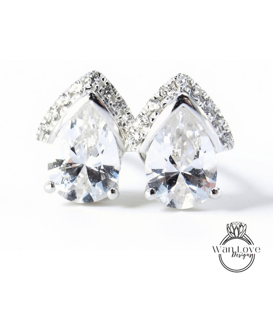 A pair of elegant earrings with large, clear gemstones set in a silver-toned design, with a diamond-encrusted accent.