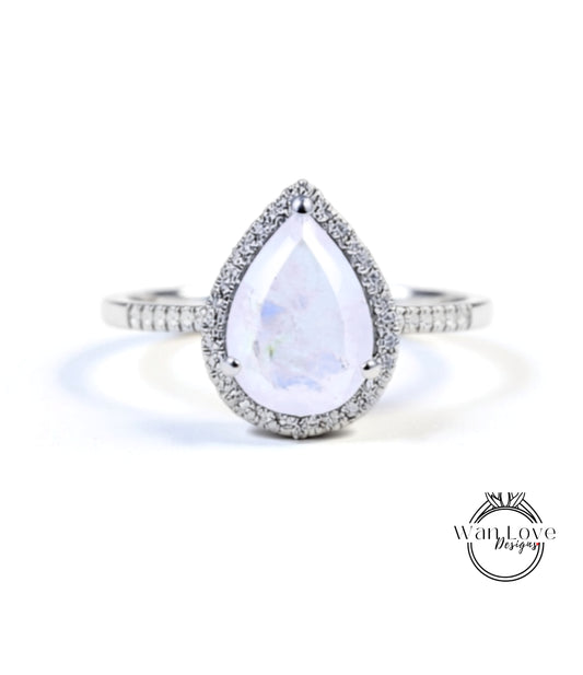 A diamond ring with a large, clear gemstone in the center, surrounded by a halo of smaller diamonds.