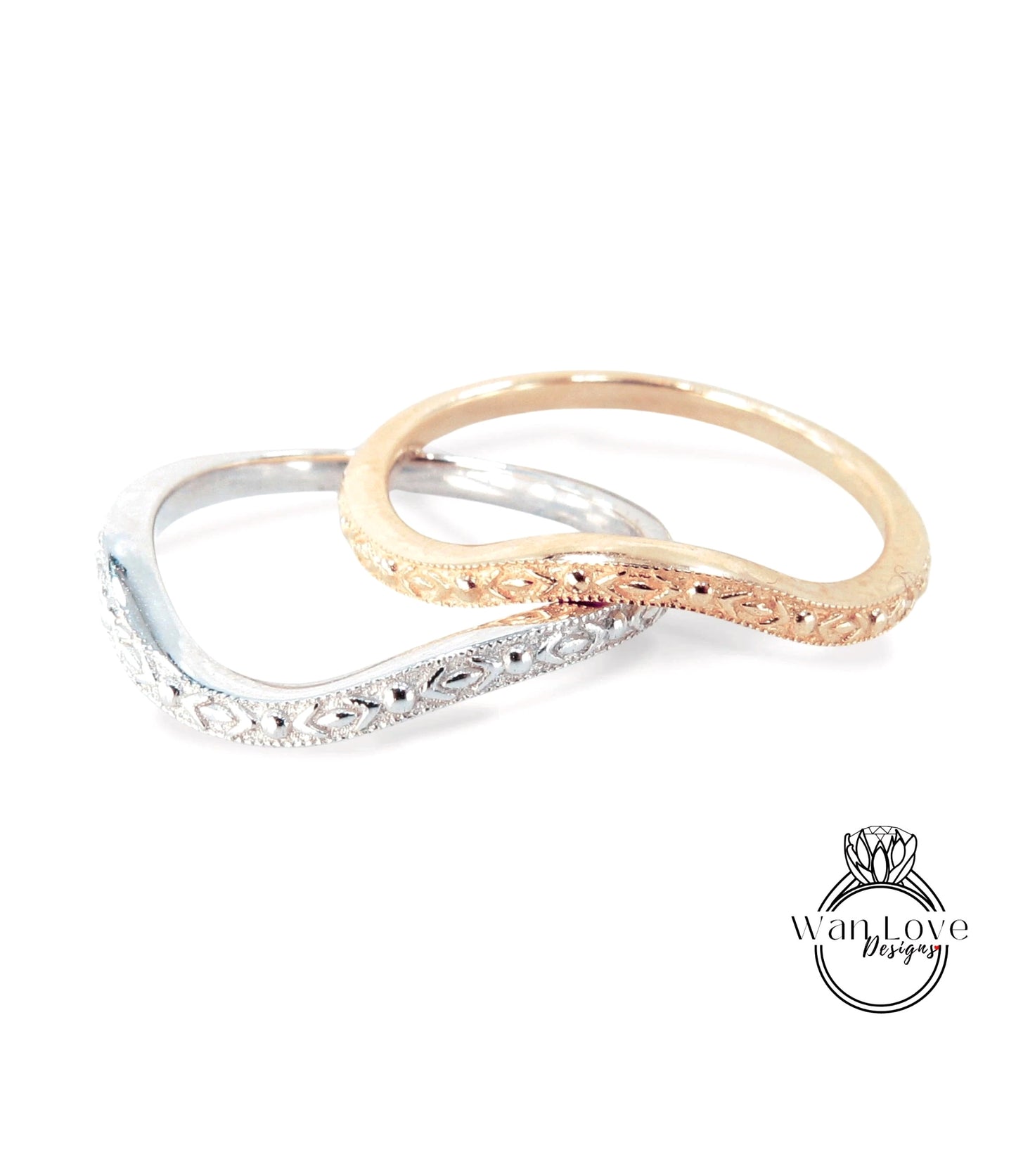 Two ornate rings, one silver and one gold, are displayed together against a white background.