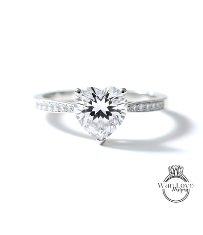 A close-up of a diamond engagement ring with a large, clear gemstone set in a silver band.