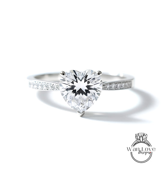 A close-up of a diamond engagement ring with a large, clear gemstone set in a silver band.