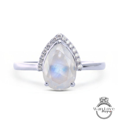 A silver ring with a large, clear gemstone in the center, surrounded by smaller diamonds.