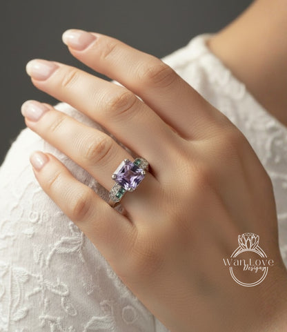 A close-up of a person's hand wearing a large, purple gemstone ring on the ring finger.
