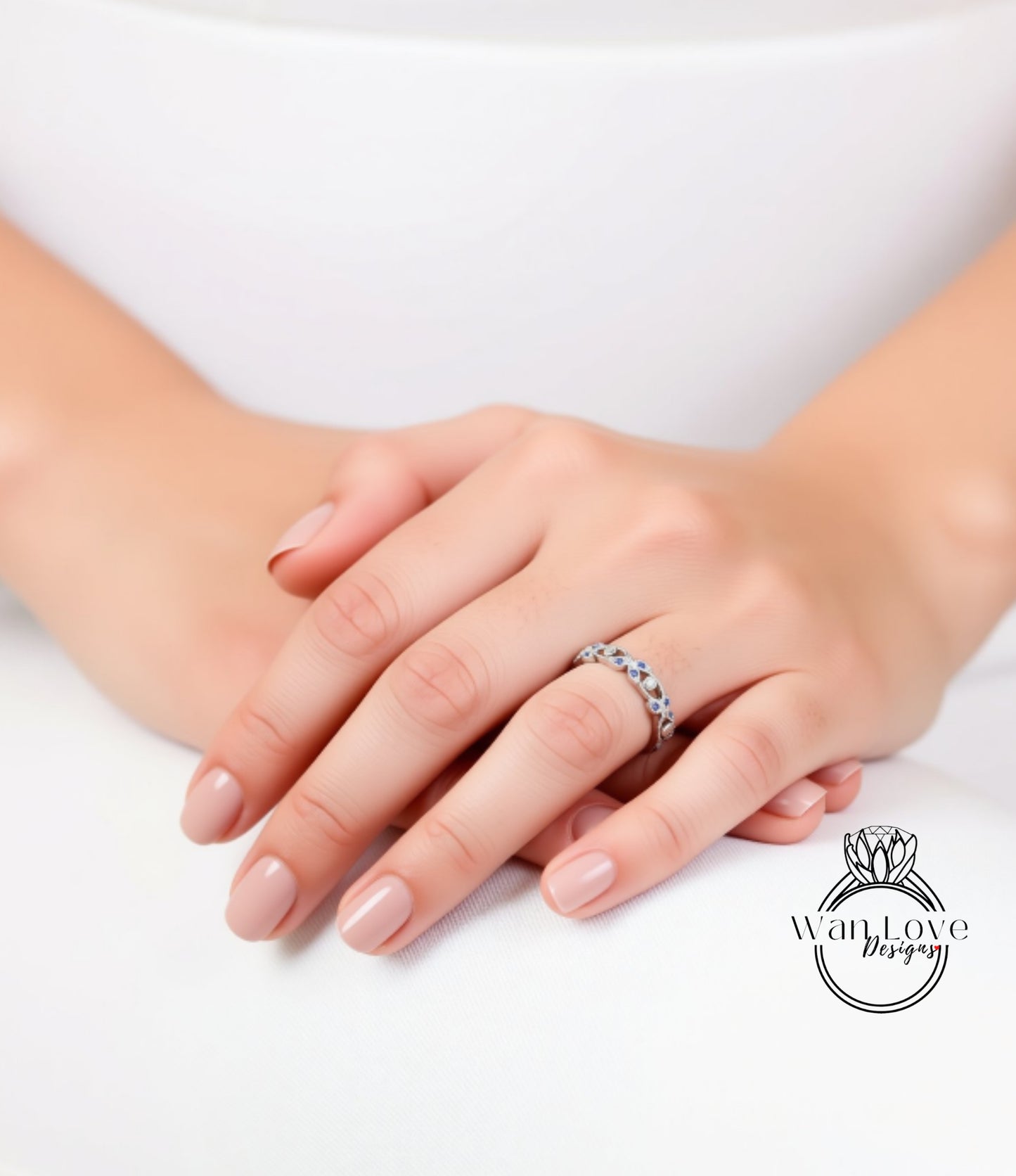 A close-up image of a person's hands wearing a ring on the ring finger.