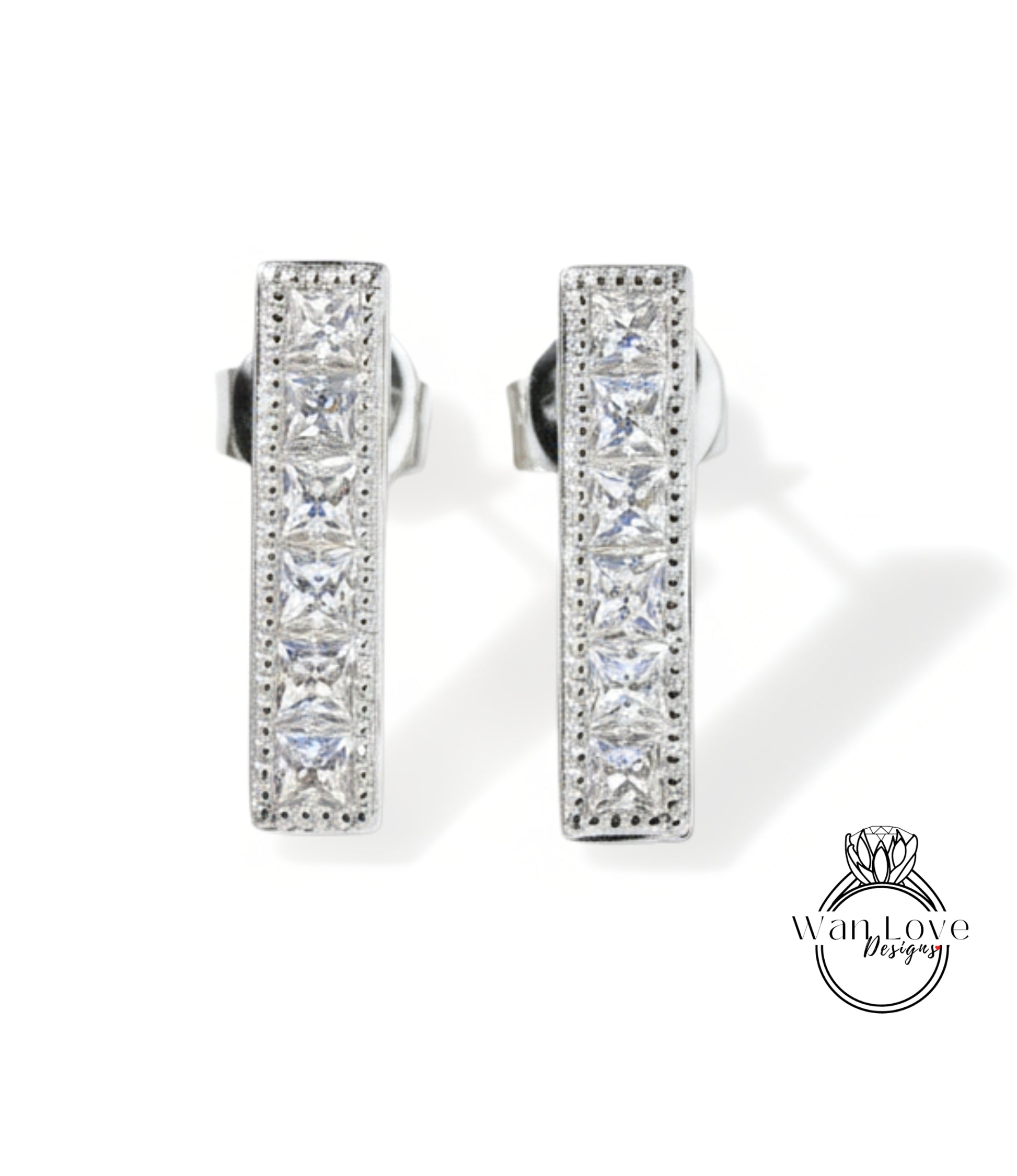A pair of elegant silver earrings with a row of small diamonds along the length of the bars.