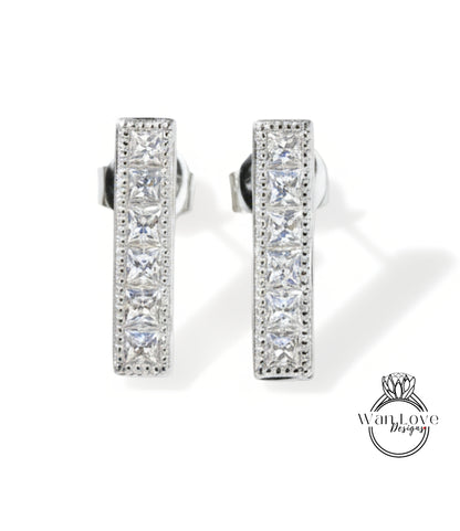 A pair of elegant silver earrings with a row of small diamonds along the length of the bars.