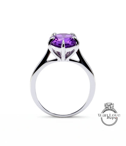 A silver ring with a large, purple gemstone set in the center.