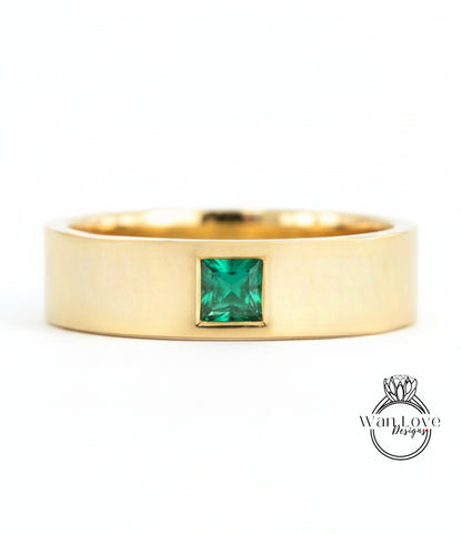 A gold ring with a large, square-cut green gemstone set in the center.