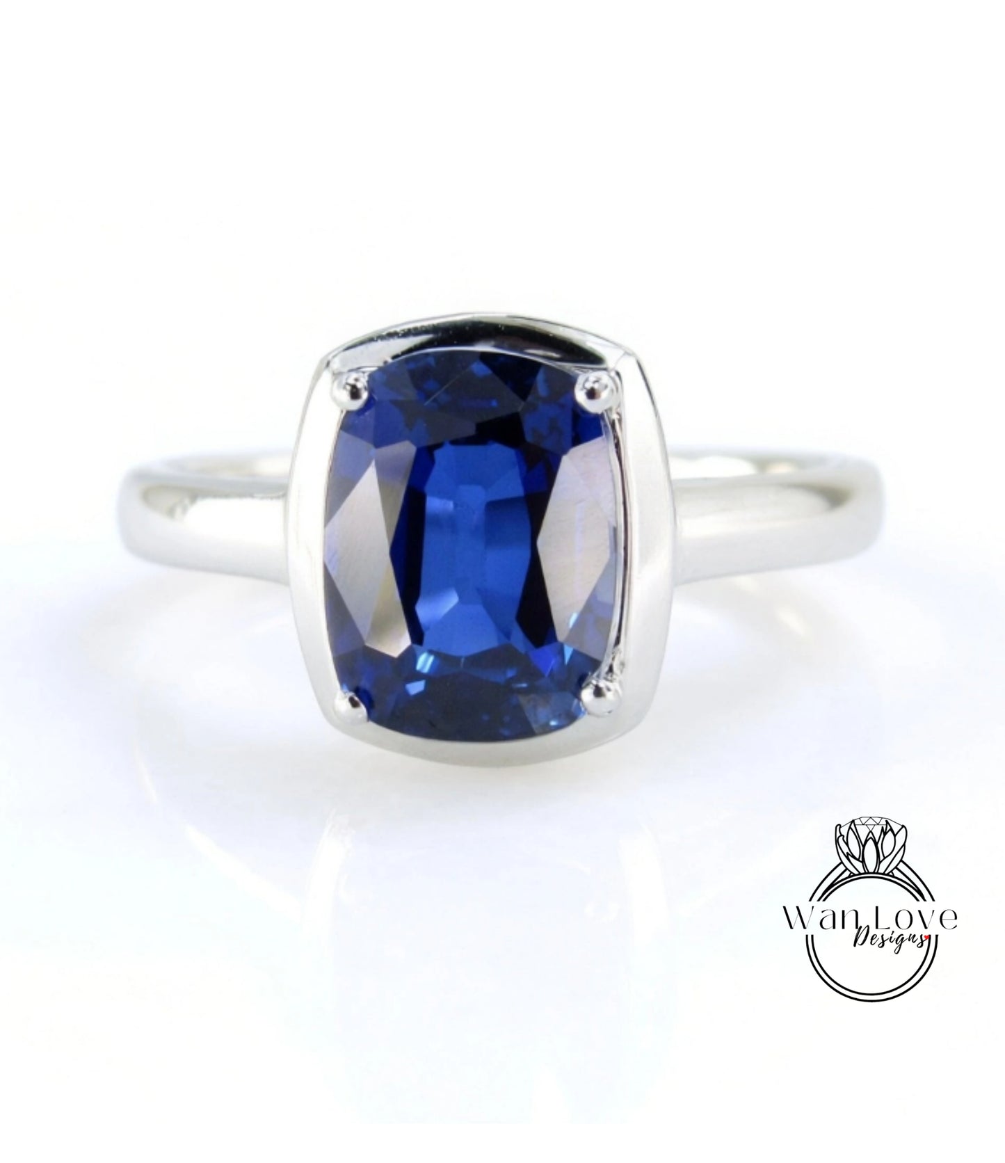 A silver ring with a large, deep blue sapphire gemstone set in the center.