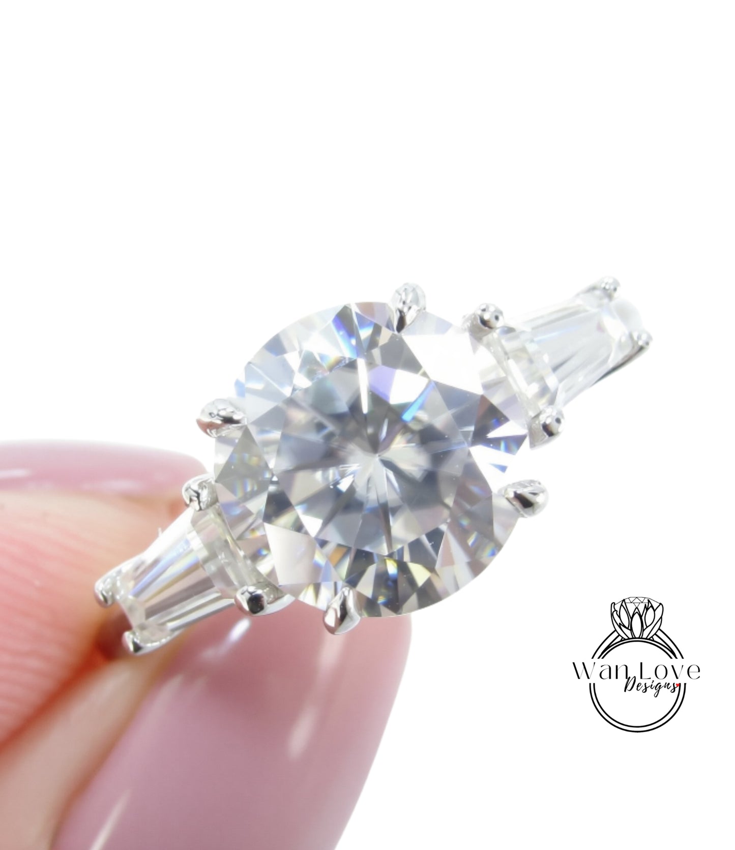 A close-up of a diamond engagement ring being held in someone's hand, showcasing the sparkling center stone surrounded by the band and accents.