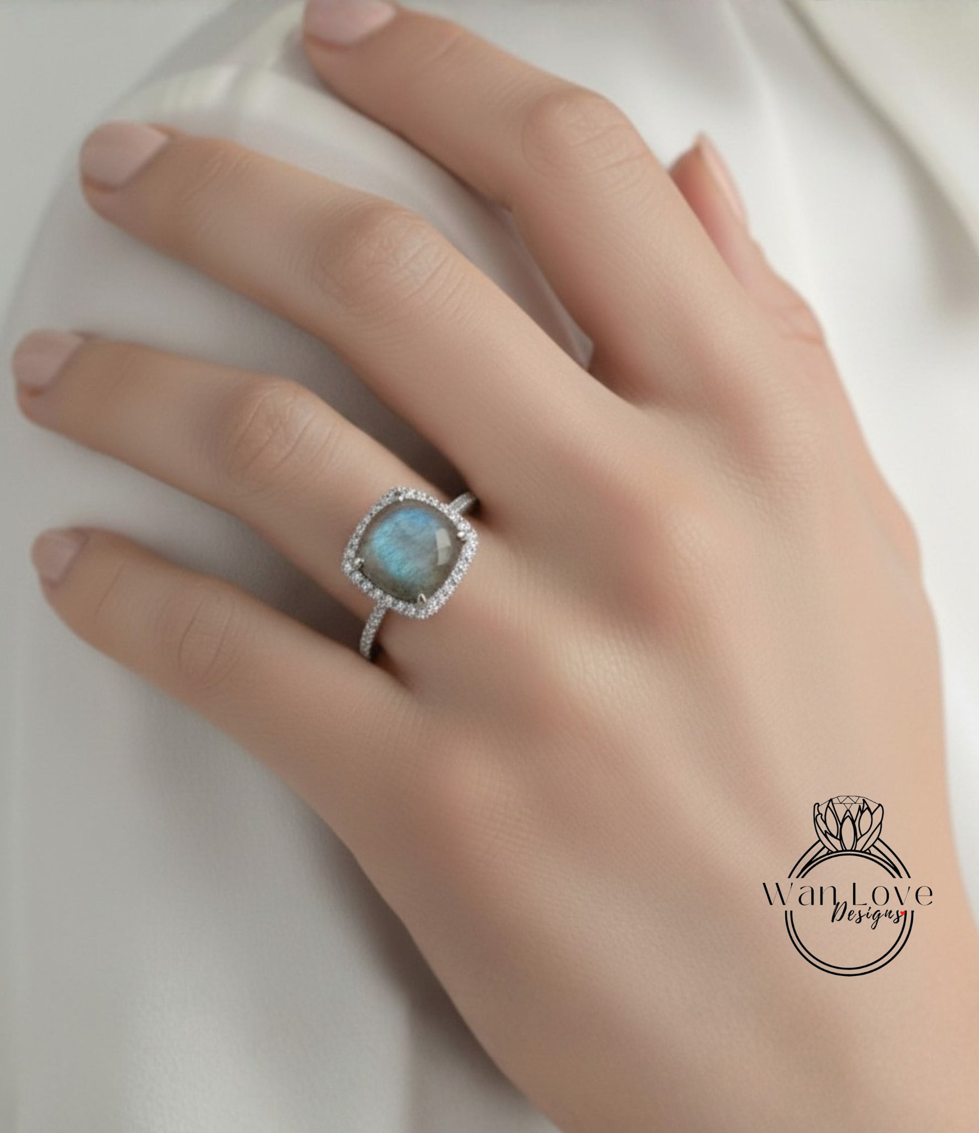 A close-up of a hand wearing a diamond ring with a blue gemstone.