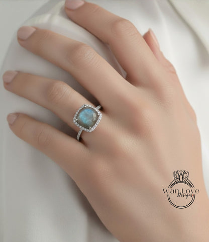 A close-up of a hand wearing a diamond ring with a blue gemstone.