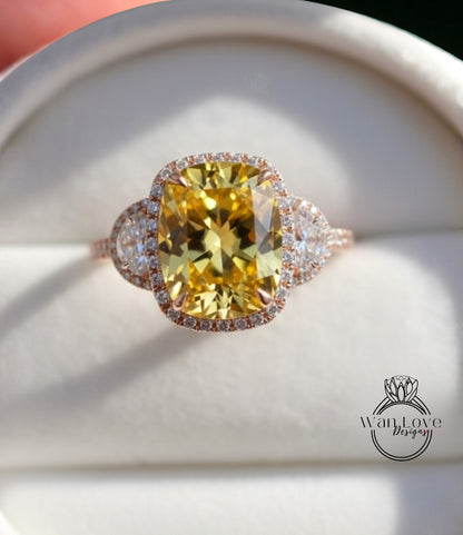 A large yellow diamond ring with a halo of smaller diamonds around the center stone, displayed in a white jewelry box.