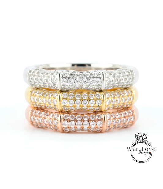 A close-up image of a ring with three distinct layers of diamond-encrusted bands, showcasing the intricate design and craftsmanship of the jewelry piece.