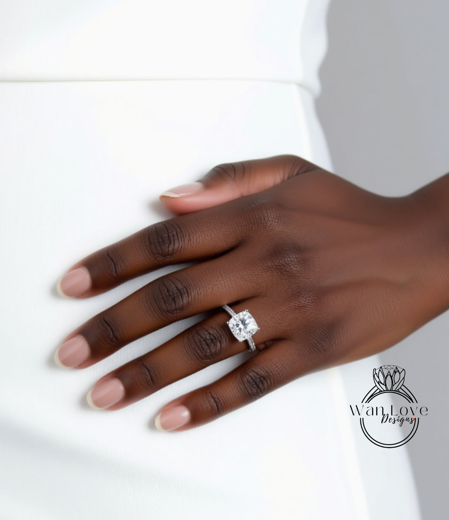 A close-up of a hand wearing a diamond engagement ring.
