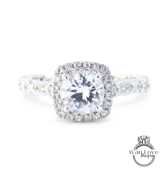 A close-up view of a diamond engagement ring with a large central diamond surrounded by smaller diamonds set in a halo of smaller diamonds.