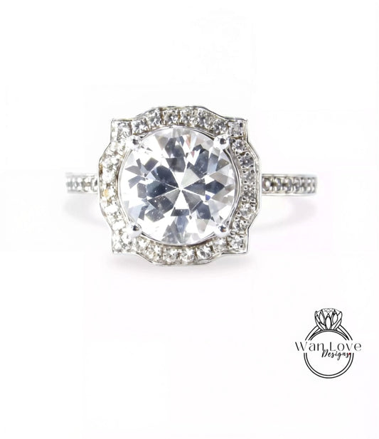 A stunning diamond engagement ring with a large central diamond surrounded by smaller diamonds set in a halo of smaller diamonds.