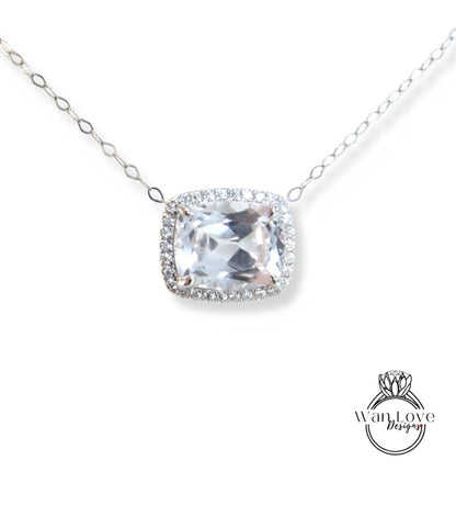 A necklace with a large, clear gemstone pendant, surrounded by a halo of smaller diamonds.