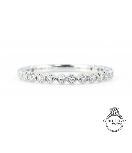A diamond-encrusted ring with a row of small diamonds set in the center, showcasing the intricate design and craftsmanship of the piece.