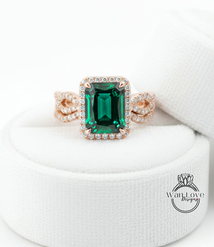 A large, green gemstone ring with a halo of smaller diamonds around it, displayed on a white background.