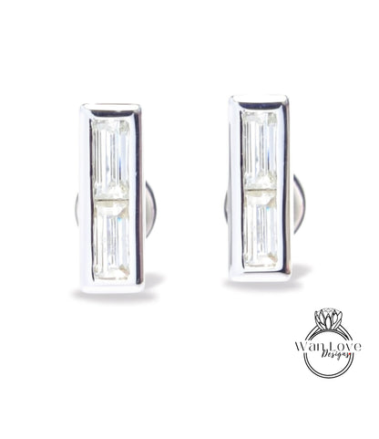 A pair of silver earrings with rectangular-shaped clear gemstones.