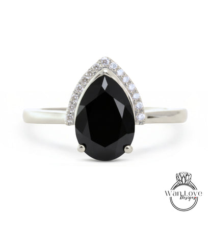 A silver ring with a large black diamond as the centerpiece, surrounded by smaller diamonds.