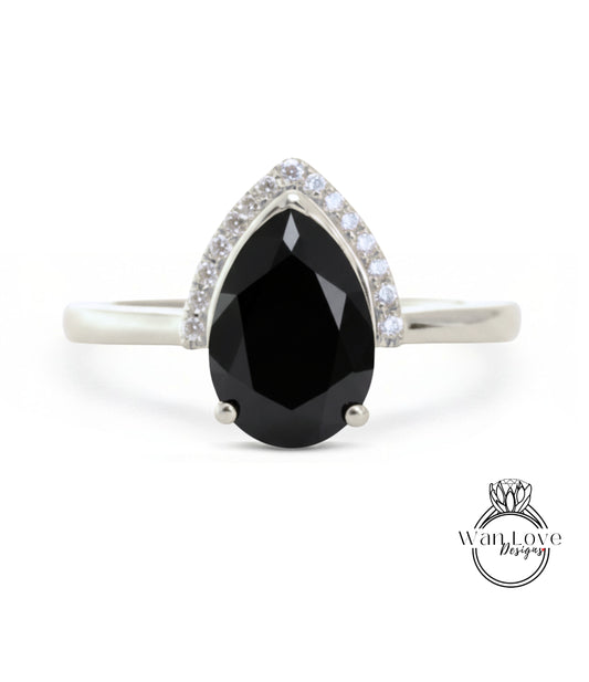 A silver ring with a large black diamond as the centerpiece, surrounded by smaller diamonds.