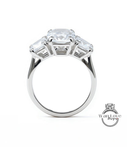 A silver ring with a large central diamond surrounded by three smaller diamonds on either side.