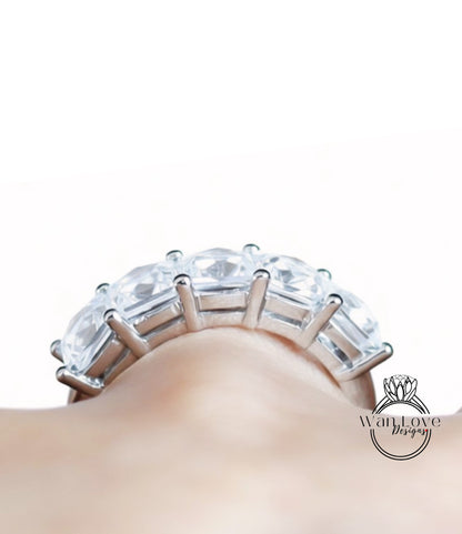 A close-up view of a large, ornate ring with multiple clear gemstones set in a silver band.