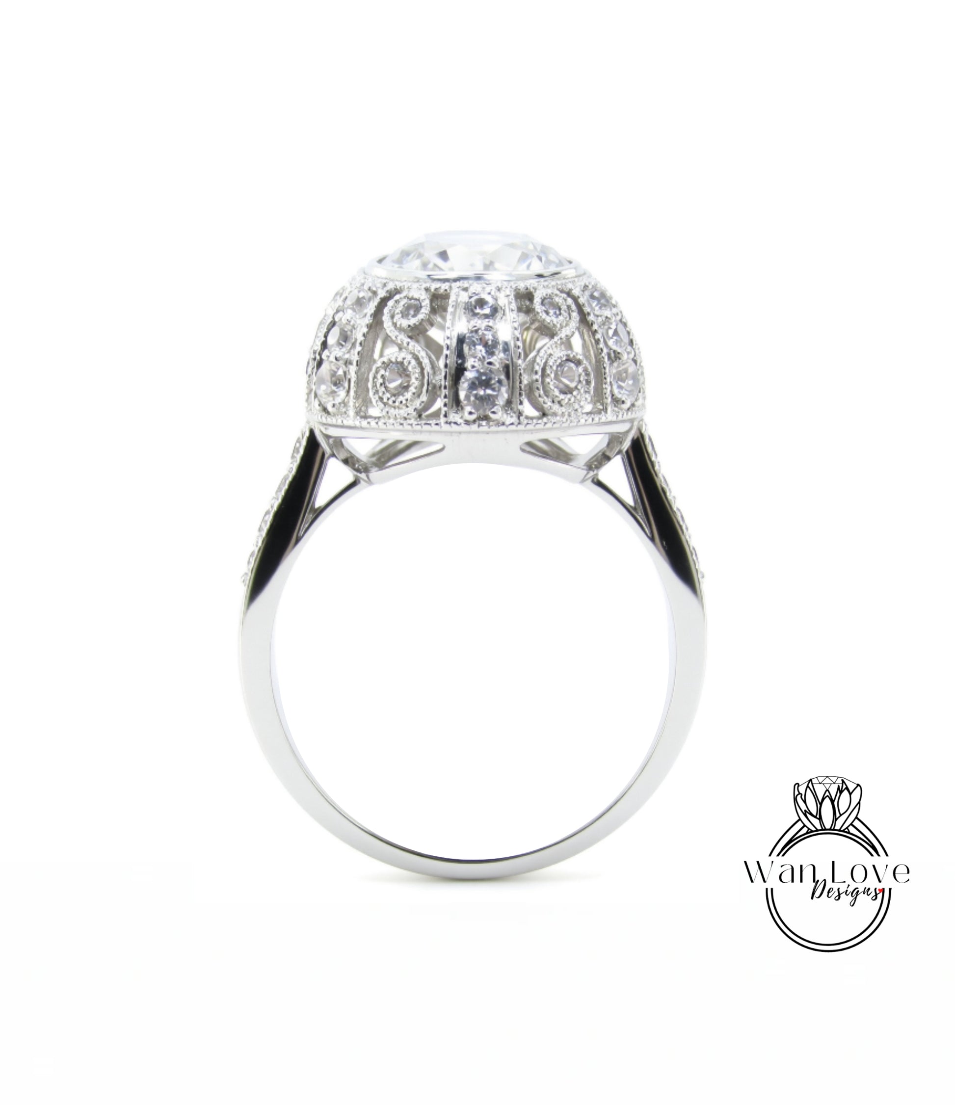 A silver ring with a large, round diamond at the center, surrounded by intricate, sparkling designs.