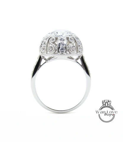 A silver ring with a large, round diamond at the center, surrounded by intricate, sparkling designs.