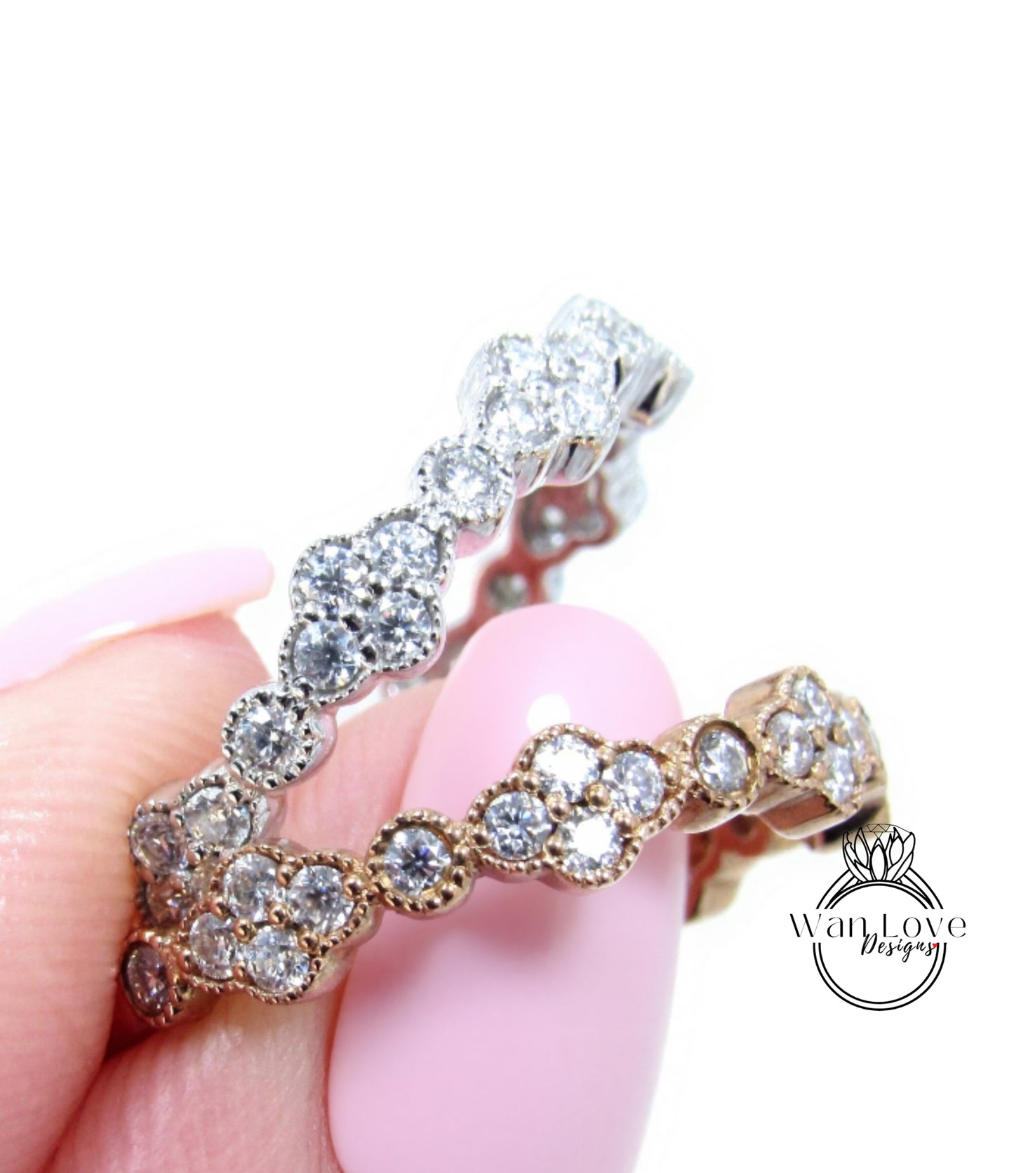 A close-up of a person's hand holding a ring with a row of small, clear gemstones set in a decorative metal band.