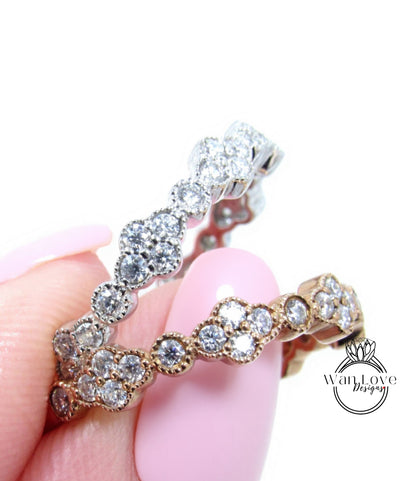 A close-up of a person's hand holding a ring with a row of small, clear gemstones set in a decorative metal band.
