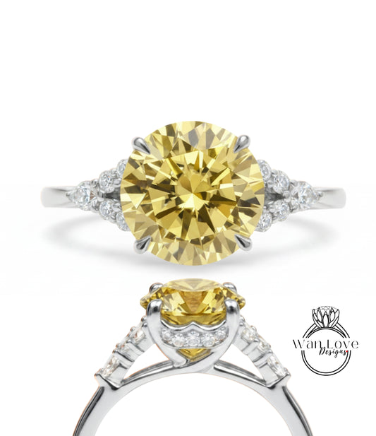 A yellow diamond engagement ring with a silver band and small diamonds.