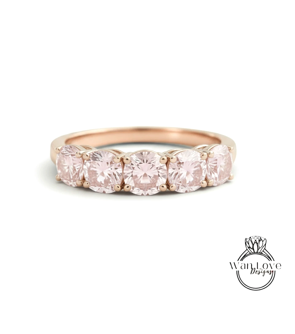 A gold ring with a row of pink diamonds set in the band.