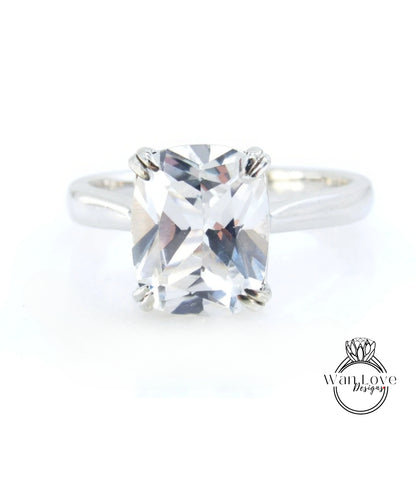 A close-up view of a diamond engagement ring with a large, clear gemstone set in a silver band.