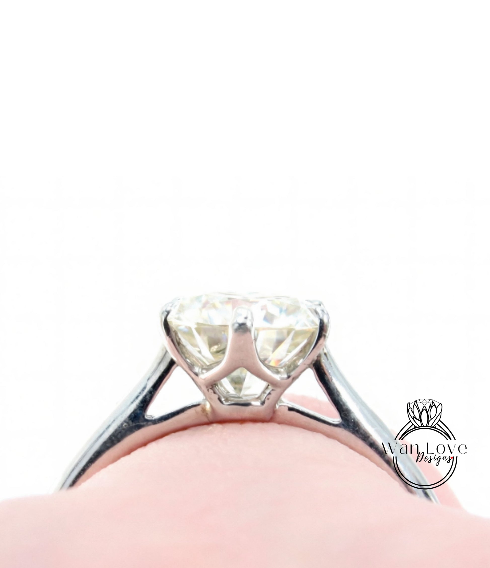 A close-up view of a diamond engagement ring on a person's finger, showcasing the sparkling center stone.