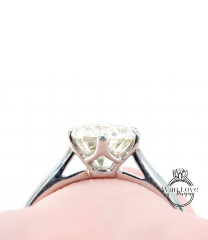 A close-up view of a diamond engagement ring on a person's finger, showcasing the sparkling center stone.