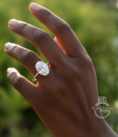 A close-up of a hand wearing a large oval-shaped diamond engagement ring.