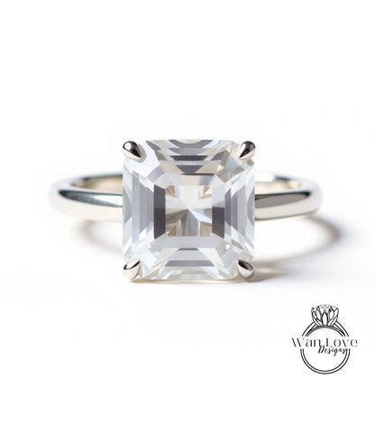 A large, clear gemstone engagement ring with a silver band.