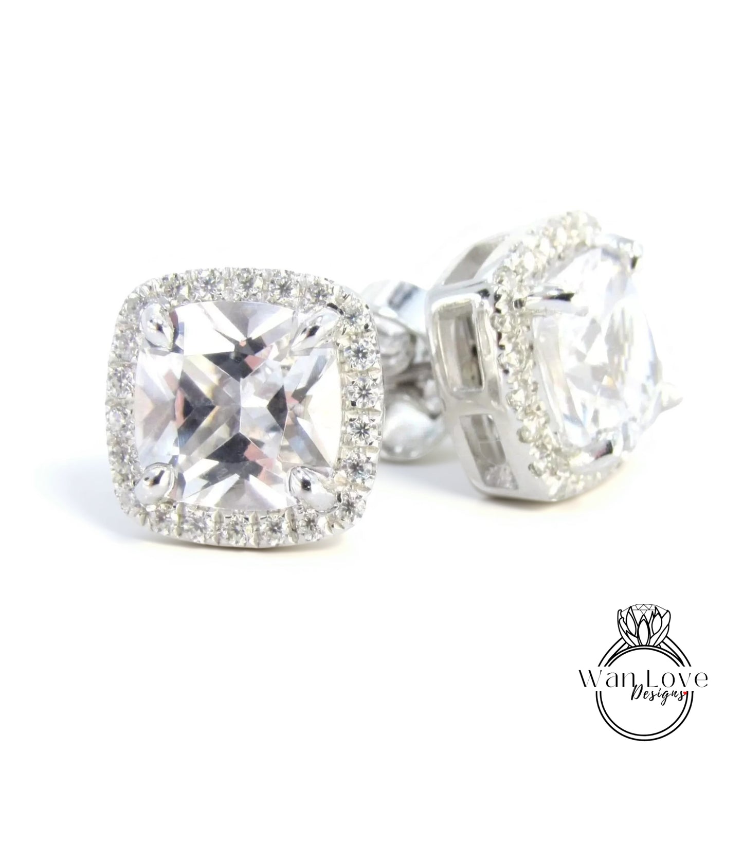 A pair of elegant earrings with large, clear gemstones set in a halo of smaller diamonds, creating a sparkling and luxurious appearance.