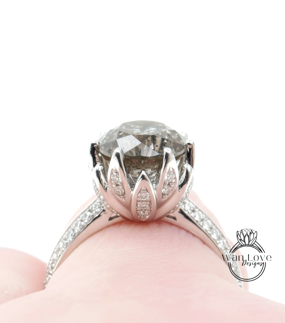 A close-up view of a silver ring with a large, round diamond set in the center, surrounded by smaller diamonds.