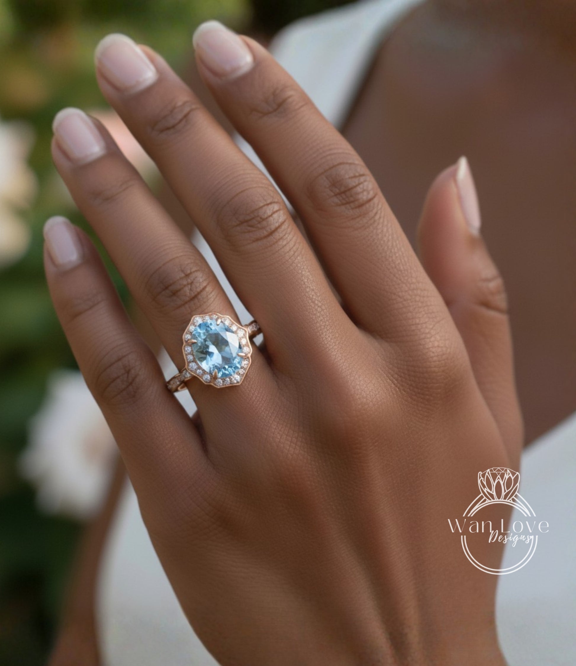 A close-up of a person's hand wearing a gold ring with a large blue gemstone, likely an aquamarine or blue topaz stone.