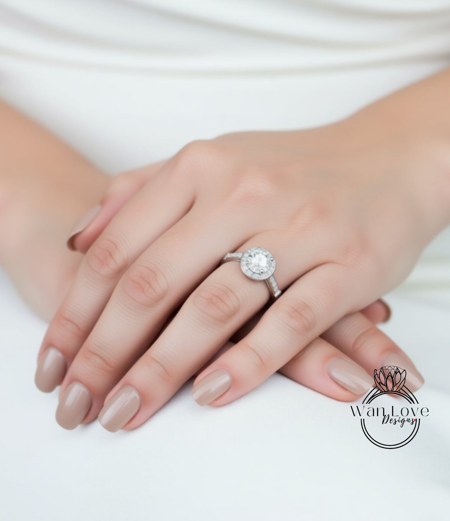 A close-up of a person's hand wearing a diamond engagement ring.