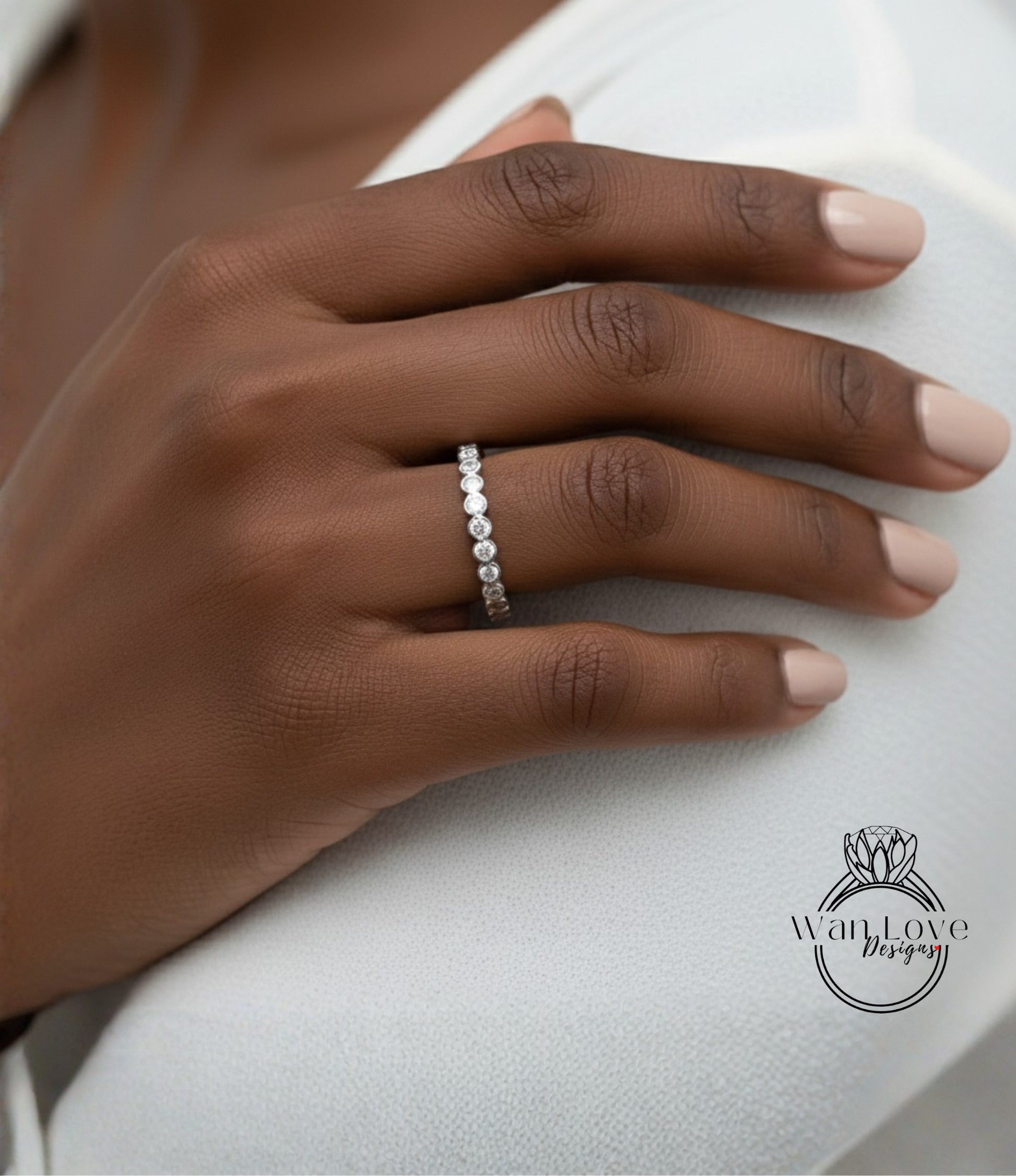 A close-up of a hand wearing a diamond ring on the ring finger.