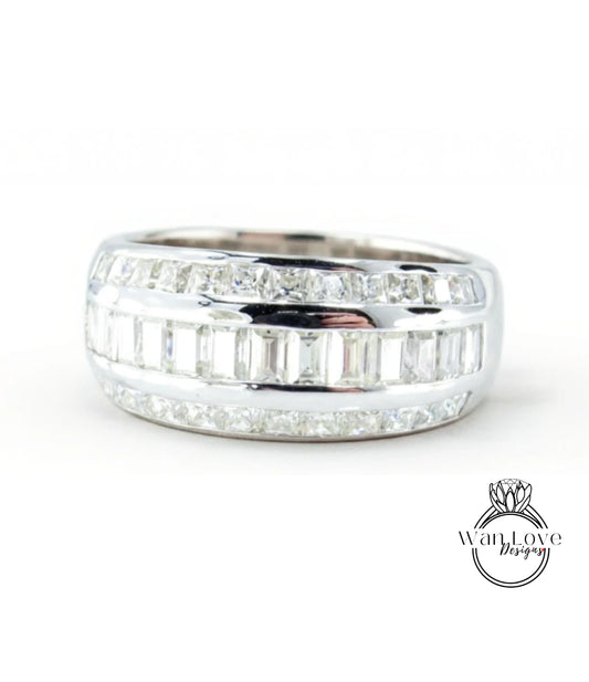A silver ring with a row of small diamonds set in it.