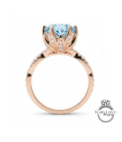 A rose gold ring with a large blue gemstone, likely a diamond, set in the center.