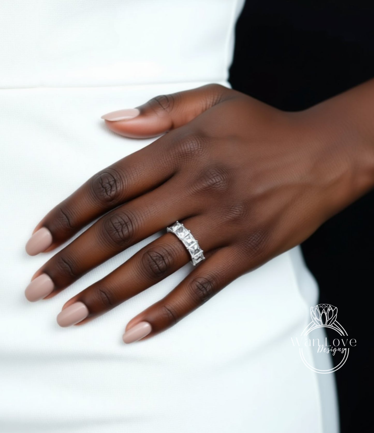 A close-up of a person's hand wearing a diamond ring on the ring finger.