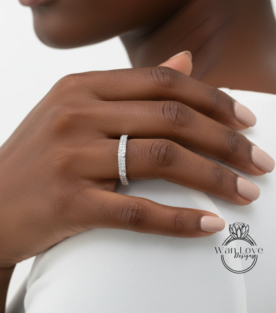A close-up of a person's hand wearing a diamond ring on the ring finger.